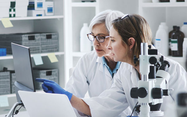 Lab workers examining a screen.